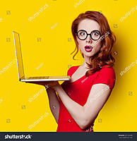 redhead-girl-with-laptop-computer-in-red-dress-on-yellow-background-281723408.jpg