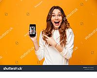 brunette-woman-in-sweater-showing-blank-smartphone-screen-and-pointing-on-it-while-1044160687.jpg